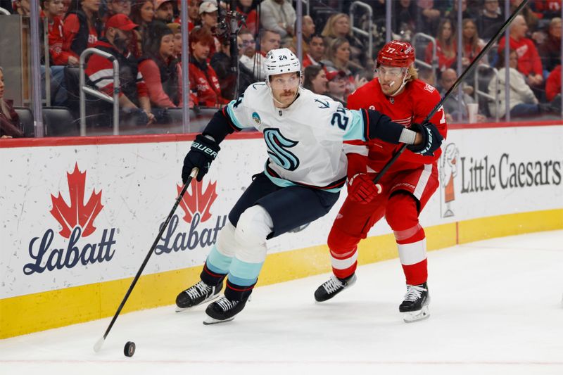 Nov 18, 2025; Detroit, Michigan, USA; Seattle Kraken defenseman Jamie Oleksiak (24) skates with he puck defended by Detroit Red Wings defenseman Simon Edvinsson (77) in the first period at Little Caesars Arena. Mandatory Credit: Rick Osentoski-Imagn Images