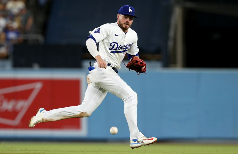 Jul 23, 2024; Los Angeles, California, USA; Los Angeles Dodgers second baseman Gavin Lux (9) chases a ground ball during the eighth inning against the San Francisco Giants at Dodger Stadium. Mandatory Credit: Jason Parkhurst-USA TODAY Sports
