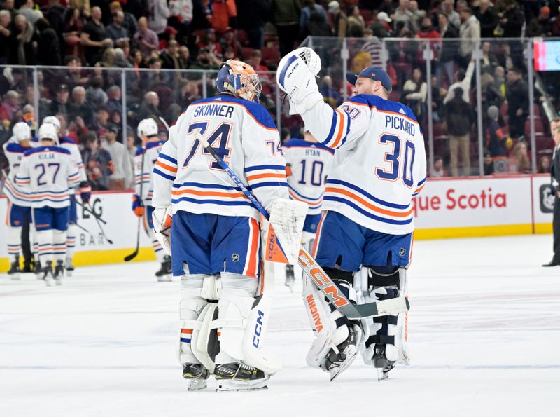 Jan 13, 2024; Montreal, Quebec, CAN; Edmonton Oilers goalie Stuart Skinner (74) and teammate goalie Calvin Pickard (30) celebrate the win against the Montreal Canadiens at the Bell Centre. Mandatory Credit: Eric Bolte-USA TODAY Sports