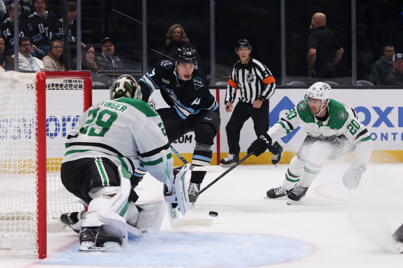 Jan 15, 2026; Salt Lake City, Utah, USA; Utah Mammoth left wing Daniil But (19) takes a shot against Dallas Stars goaltender Jake Oettinger (29) and defenseman Kyle Capobianco (20) during the second period at Delta Center. Mandatory Credit: Rob Gray-Imagn Images