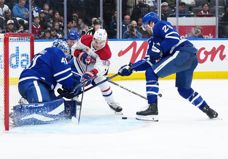 Oct 8, 2025; Toronto, Ontario, CAN; Montreal Canadiens right wing Ivan Demidov (93) battles for the puck with Toronto Maple Leafs defenseman Brandon Carlo (25) during the second period at Scotiabank Arena. Mandatory Credit: Nick Turchiaro-Imagn Images