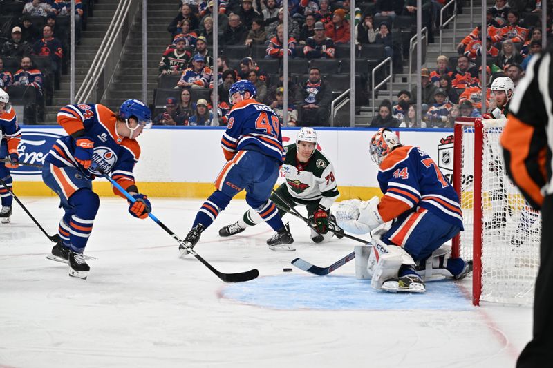 Dec 2, 2025; Edmonton, Alberta, CAN; Edmonton Oilers center Connor Clattenburg (64) with Oilers defenseman Ty Emberson (49) battle for the puck with Minnesota Wild center Nico Sturm (78) in front of Oilers goalie Stuart Skinner (74) during the second period at Rogers Place. Mandatory Credit: Walter Tychnowicz-Imagn Images