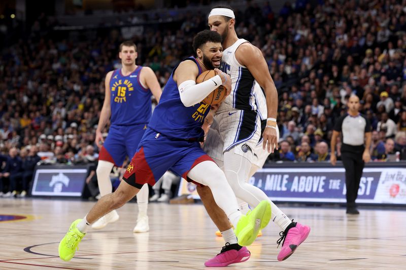 DENVER, COLORADO - JANUARY 05: Jamal Murray #27 of the Denver Nuggets drives against Jalen Suggs #4 of the Orlando Magic in the fourth quarter at Ball Arena on January 05, 2024 in Denver, Colorado.  NOTE TO USER: User expressly acknowledges and agrees that, by downloading and or using this photograph, User is consenting to the terms and conditions of the Getty Images License Agreement.  (Photo by Matthew Stockman/Getty Images)