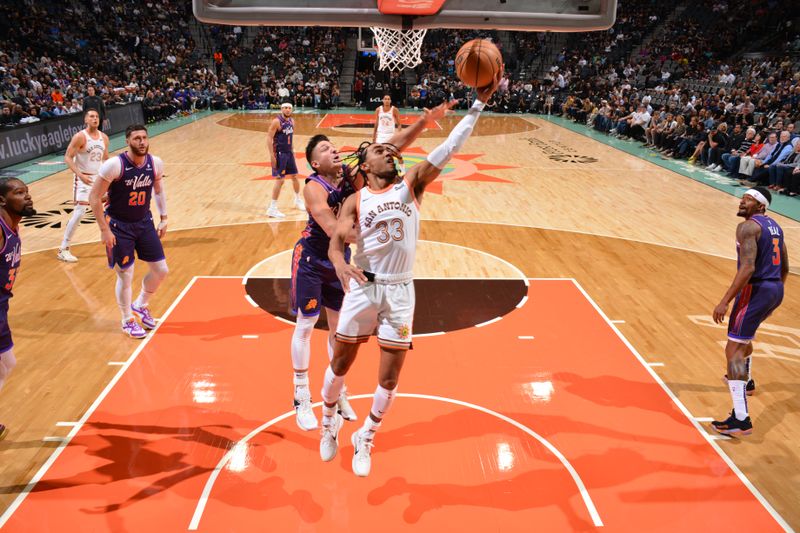 SAN ANTONIO, TX - MARCH 25: Tre Jones #33 of the San Antonio Spurs drives to the basket during the game against the Phoenix Suns on March 25, 2024 at the AT&T Center in San Antonio, Texas. NOTE TO USER: User expressly acknowledges and agrees that, by downloading and or using this photograph, user is consenting to the terms and conditions of the Getty Images License Agreement. Mandatory Copyright Notice: Copyright 2024 NBAE (Photos by Jesse D. Garrabrant/NBAE via Getty Images)