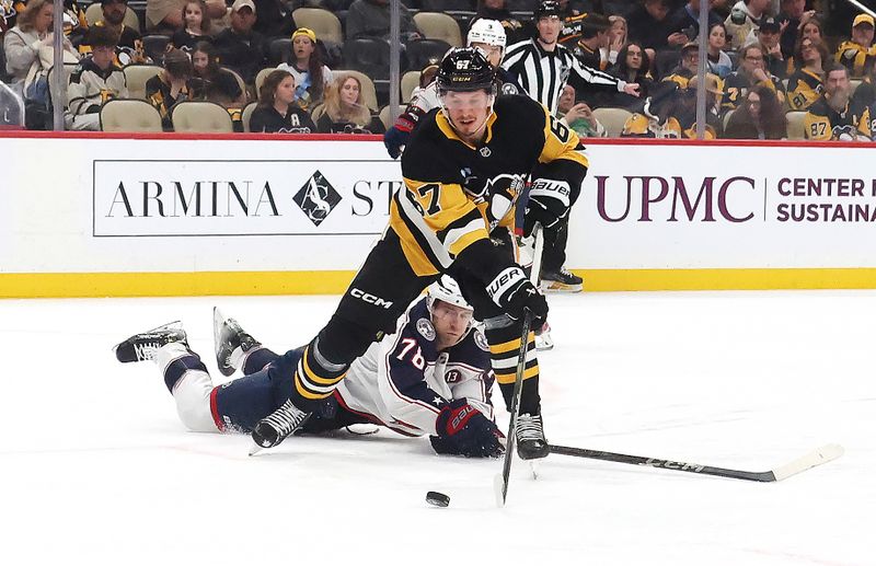 Mar 21, 2025; Pittsburgh, Pennsylvania, USA;  Pittsburgh Penguins right wing Rickard Rakell (67) moves the puck against Columbus Blue Jackets defenseman Damon Severson (78) during the third period at PPG Paints Arena. Mandatory Credit: Charles LeClaire-Imagn Images