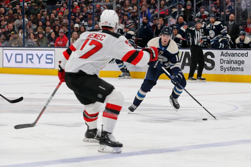 Jan 19, 2024; Columbus, Ohio, USA; Columbus Blue Jackets center Adam Fantilli (11) carries the puck as New Jersey Devils defenseman  Simon Nemec (17) \defends during the first period at Nationwide Arena. Mandatory Credit: Russell LaBounty-USA TODAY Sports