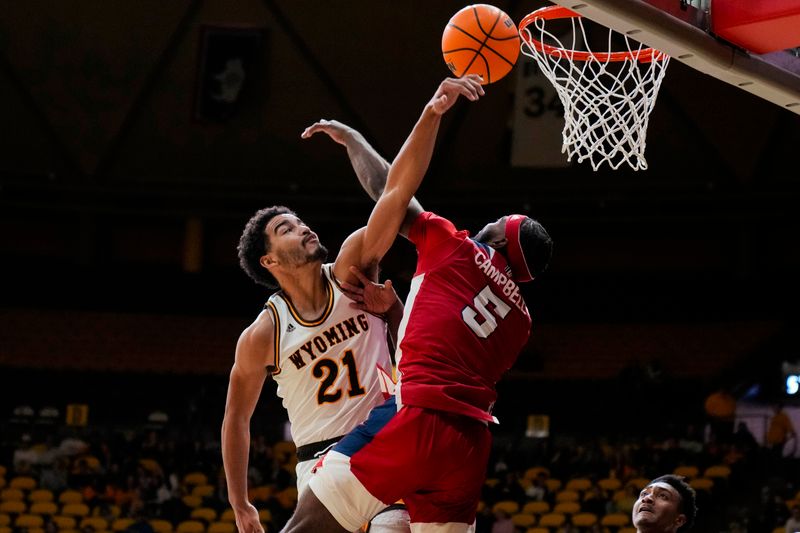 Jan 31, 2023; Laramie, Wyoming, USA; Wyoming Cowboys guard Noah Reynolds (21) has his shot blocked by Fresno State Bulldogs guard Jordan Campbell (5) during the second half at Arena-Auditorium. Mandatory Credit: Troy Babbitt-USA TODAY Sports