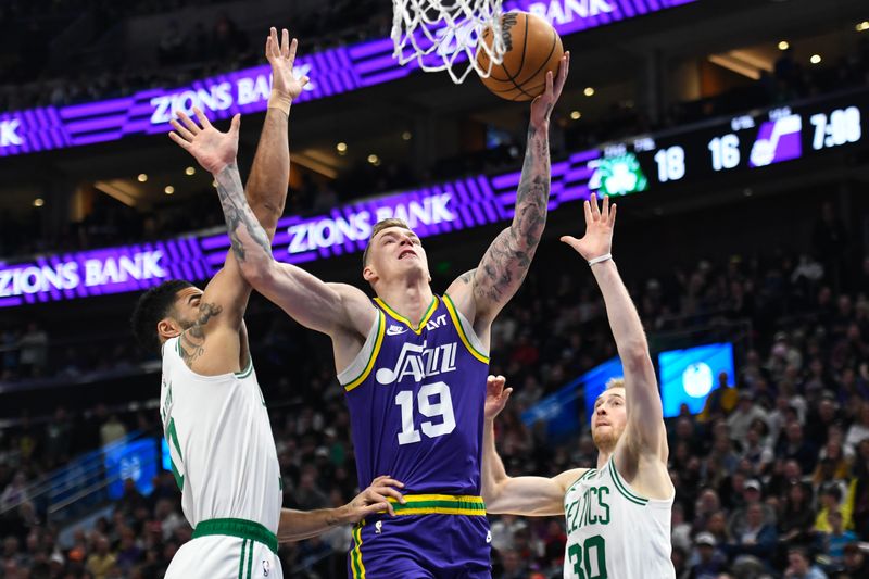 SALT LAKE CITY, UTAH - MARCH 12: Luka Samanic #19 of the Utah Jazz shoots between Jayson Tatum #0 and Sam Hauser #30 of the Boston Celtics during the first half of a game at Delta Center on March 12, 2024 in Salt Lake City, Utah. NOTE TO USER: User expressly acknowledges and agrees that, by downloading and or using this photograph, User is consenting to the terms and conditions of the Getty Images License Agreement. (Photo by Alex Goodlett/Getty Images)