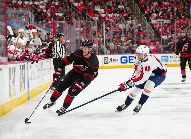 May 12, 2025; Raleigh, North Carolina, USA; Carolina Hurricanes right wing Andrei Svechnikov (37) skates with the puck past Washington Capitals left wing Pierre-Luc Dubois (80) during the first period in game four of the second round of the 2025 Stanley Cup Playoffs at Lenovo Center. Mandatory Credit: James Guillory-Imagn Images
