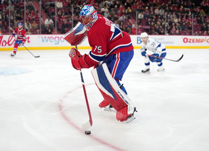 Dec 9, 2025; Montreal, Quebec, CAN; Montreal Canadiens goalie Jakub Dobes (75) plays the puck during the first period of the game against the Tampa Bay Lightning at the Bell Centre. Mandatory Credit: Eric Bolte-Imagn Images