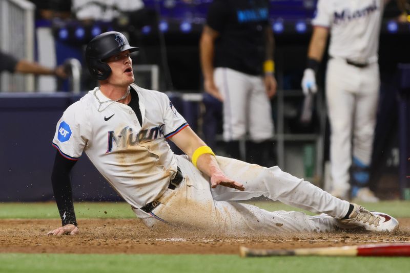 Sep 4, 2024; Miami, Florida, USA; Miami Marlins right fielder Griffin Conine (56) slides at home plate and scores after a double by catcher Nick Fortes (not pictured) against the Washington Nationals during the sixth inning at loanDepot Park. Mandatory Credit: Sam Navarro-Imagn Images