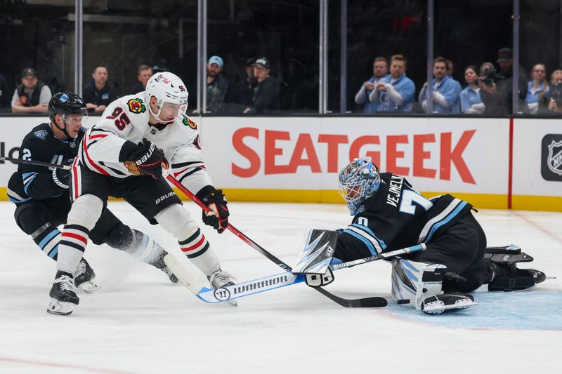 Feb 25, 2025; Salt Lake City, Utah, USA; Utah Hockey Club goaltender Karel Vejmelka (70) blocks the shot of Chicago Blackhawks right wing Ilya Mikheyev (95) during the second period at Delta Center. Mandatory Credit: Rob Gray-Imagn Images