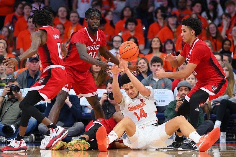 Feb 14, 2023; Syracuse, New York, USA; Syracuse Orange center Jesse Edwards (14) passes the ball from the floor between North Carolina State Wolfpack forward Ebenezer Dowuona (21) and guard Jack Clark (5) during the second half at the JMA Wireless Dome. Mandatory Credit: Rich Barnes-USA TODAY Sports