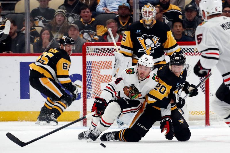 Oct 10, 2023; Pittsburgh, Pennsylvania, USA; Chicago Blackhawks left wing Boris Katchouk (14) and Pittsburgh Penguins center Lars Eller (20) look for a loose puck during the third period at the PPG Paints Arena. Chicago won 4-2. Mandatory Credit: Charles LeClaire-USA TODAY Sports