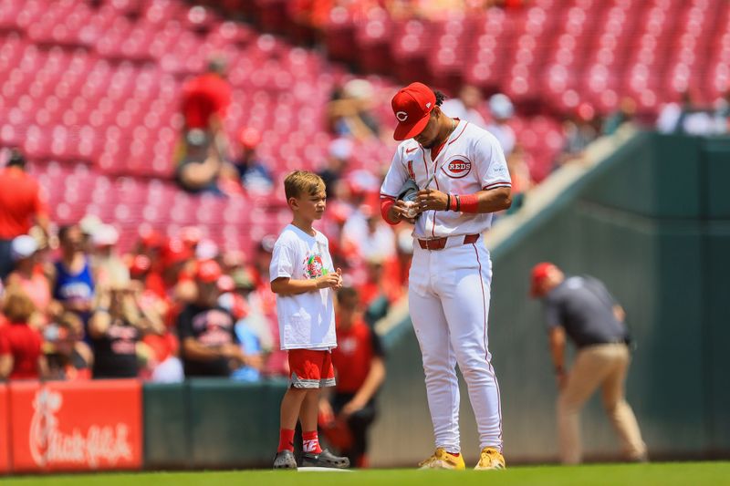 Jul 14, 2024; Cincinnati, Ohio, USA; Cincinnati Reds third baseman Santiago Espinal (4) signs an autograph before the game against the Miami Marlins at Great American Ball Park. Mandatory Credit: Katie Stratman-USA TODAY Sports