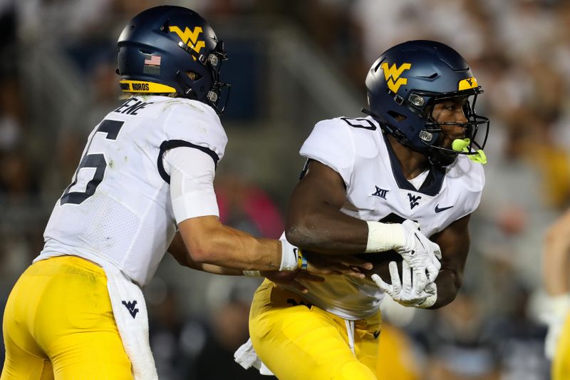 Sep 2, 2023; University Park, Pennsylvania, USA; West Virginia Mountaineers quarterback Garrett Greene (6) hands off the ball to running back Jaylen Anderson (0) during the fourth quarter against the Penn State Nittany Lions at Beaver Stadium. Penn State defeated West Virginia 38-15. Mandatory Credit: Matthew O'Haren-USA TODAY Sports