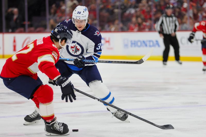 Nov 24, 2023; Sunrise, Florida, USA; Winnipeg Jets center Morgan Barron (36) moves the puck against Florida Panthers defenseman Brandon Montour (62) during the first period at Amerant Bank Arena. Mandatory Credit: Sam Navarro-USA TODAY Sports