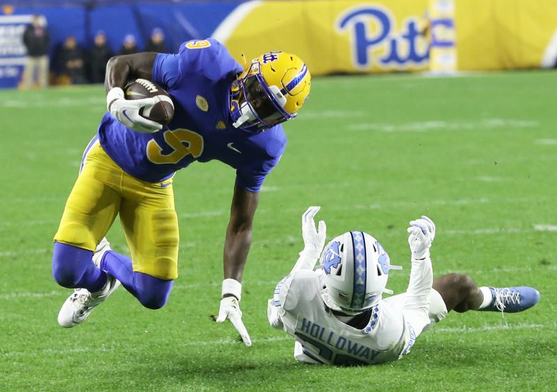 Sep 23, 2023; Pittsburgh, Pennsylvania, USA; Pittsburgh Panthers place kicker Ben Sauls (90) is tackled after a catch by North Carolina Tar Heels defensive back Tayon Holloway (20) during the first quarter at Acrisure Stadium. Mandatory Credit: Charles LeClaire-USA TODAY Sports