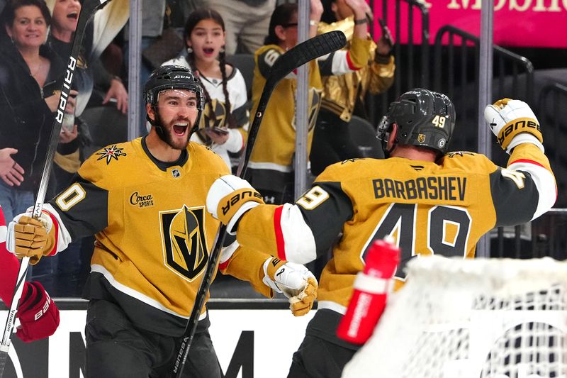 Mar 22, 2025; Las Vegas, Nevada, USA; Vegas Golden Knights center Nicolas Roy (10) celebrates with Vegas Golden Knights center Ivan Barbashev (49) after scoring a goal against the Detroit Red Wings during the first period at T-Mobile Arena. Mandatory Credit: Stephen R. Sylvanie-Imagn Images
