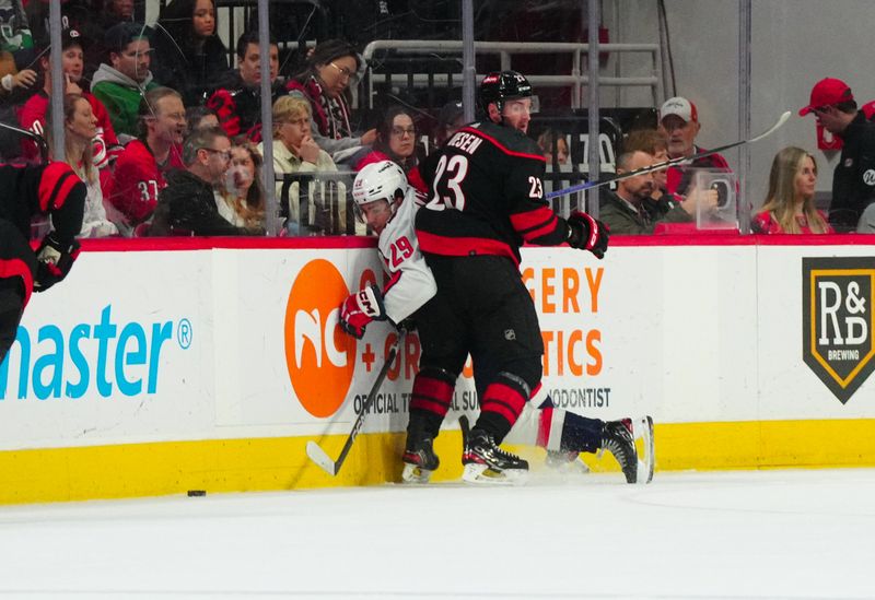 Apr 5, 2024; Raleigh, North Carolina, USA; Carolina Hurricanes right wing Stefan Noesen (23) checks Washington Capitals center Hendrix Lapierre (29) during the second period at PNC Arena. Mandatory Credit: James Guillory-USA TODAY Sports