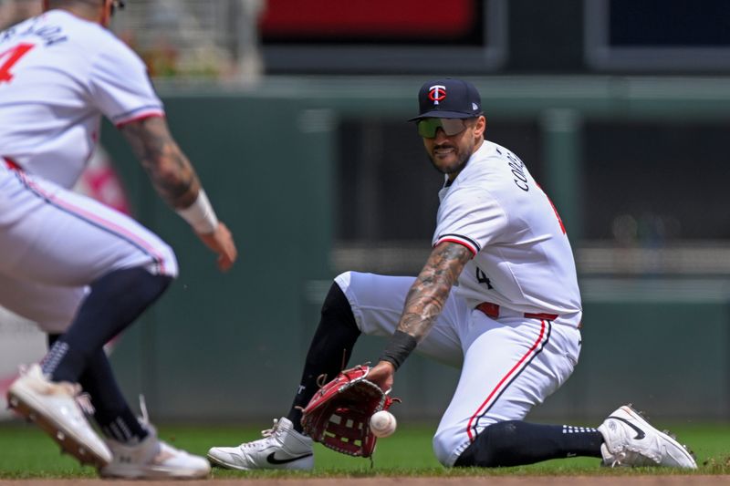 May 25, 2024; Minneapolis, Minnesota, USA;  Minnesota Twins infielder Carlos Correa (4) makes a sliding stop on a ground ball against the Texas Rangers during the third inning at Target Field. Mandatory Credit: Nick Wosika-USA TODAY Sports