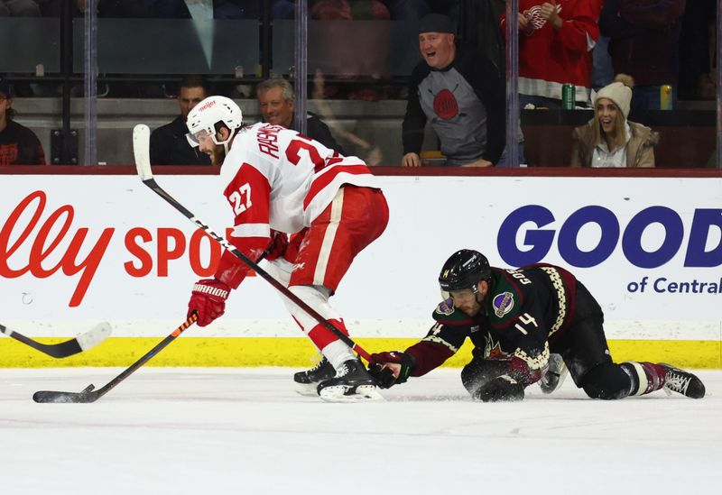 Jan 17, 2023; Tempe, Arizona, USA; Detroit Red Wings center Michael Rasmussen (27) moves the puck against Arizona Coyotes defenseman Shayne Gostisbehere (14) in the third period at Mullett Arena. Mandatory Credit: Mark J. Rebilas-USA TODAY Sports