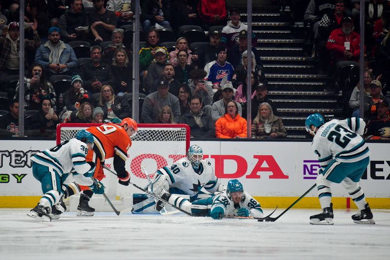 Apr 1, 2025; Anaheim, California, USA; San Jose Sharks defenseman Lucas Carlsson (36) and right wing Barclay Goodrow (23) help goaltender Alexandar Georgiev (40) defend the goal against Anaheim Ducks right wing Troy Terry (19) during the third period at Honda Center. Mandatory Credit: Gary A. Vasquez-Imagn Images