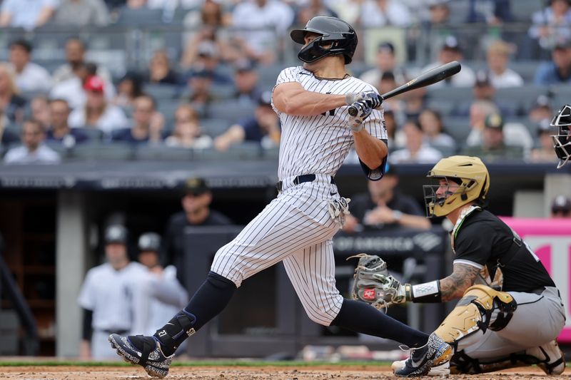 May 18, 2024; Bronx, New York, USA; New York Yankees designated hitter Giancarlo Stanton (27) follows through on an RBI double during the first inning against the Chicago White Sox at Yankee Stadium. Mandatory Credit: Brad Penner-USA TODAY Sports