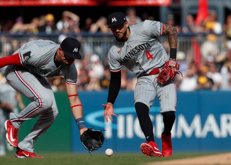 Jun 8, 2024; Pittsburgh, Pennsylvania, USA;  Minnesota Twins third baseman Royce Lewis (left) and shortstop Carlos Correa (4) reach for a ball hit by Pittsburgh Pirates third baseman Ke'Bryan Hayes (not pictured) during the fifth inning at PNC Park. Pittsburgh won 4-0. Mandatory Credit: Charles LeClaire-USA TODAY Sports