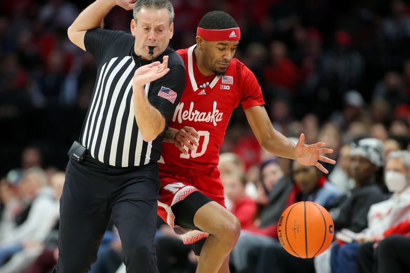 Feb 29, 2024; Columbus, Ohio, USA;  Nebraska Cornhuskers guard Jamarques Lawrence (10) plays for the ball and collides with the referee during the first half against the Ohio State Buckeyes at Value City Arena. Mandatory Credit: Joseph Maiorana-USA TODAY Sports