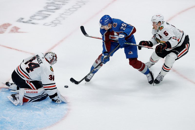 Oct 19, 2023; Denver, Colorado, USA; Colorado Avalanche center Nathan MacKinnon (29) controls the puck under pressure from Chicago Blackhawks defenseman Connor Murphy (5) as goaltender Petr Mrazek (34) looks on in the third period at Ball Arena. Mandatory Credit: Isaiah J. Downing-USA TODAY Sports