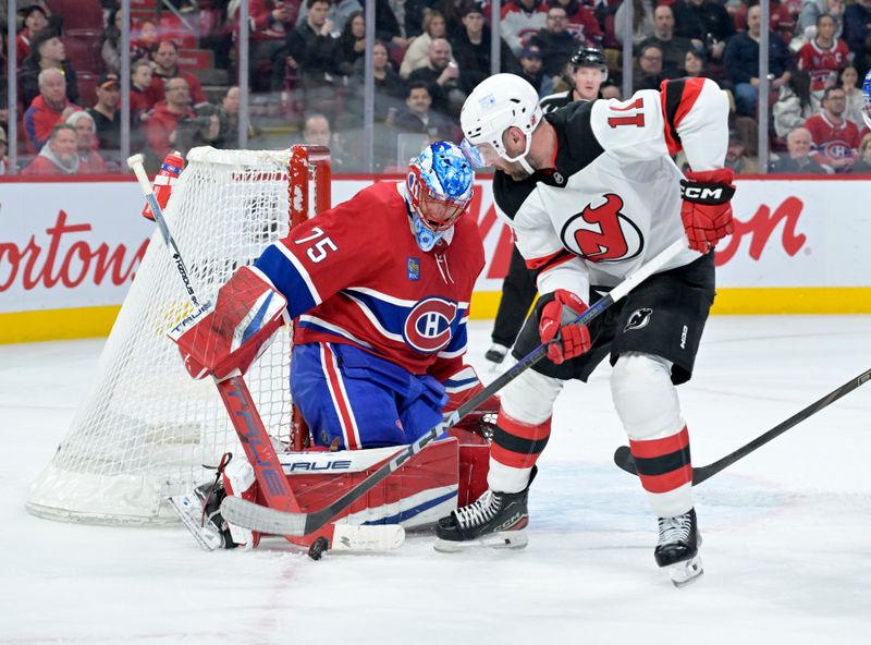 Jan 25, 2025; Montreal, Quebec, CAN; Montreal Canadiens goalie Jakub Dobes (75) stops New Jersey Devils forward Stefan Noesen (11) during the third period at the Bell Centre. Mandatory Credit: Eric Bolte-Imagn Images