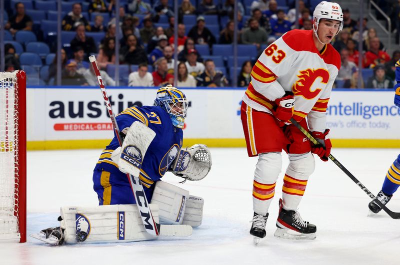 Oct 19, 2023; Buffalo, New York, USA;  Calgary Flames center Adam Ruzicka (63) looks to deflect a shot as Buffalo Sabres goaltender Devon Levi (27) makes a pad save during the first period at KeyBank Center. Mandatory Credit: Timothy T. Ludwig-USA TODAY Sports