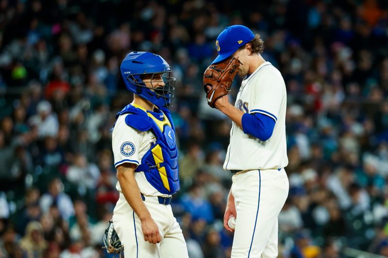 Apr 28, 2024; Seattle, Washington, USA; Seattle Mariners starting pitcher Logan Gilbert (36, right) stands on the mound with catcher Seby Zavala (33) shortly before a pitching change against the Arizona Diamondbacks during the seventh inning at T-Mobile Park. Mandatory Credit: Joe Nicholson-USA TODAY Sports