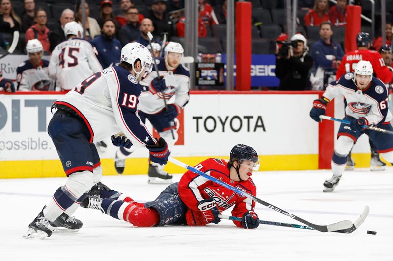 Sep 27, 2024; Washington, District of Columbia, USA; Columbus Blue Jackets center Adam Fantilli (19) knocks Washington Capitals forward Andrew Cristell (28) to the ice while battling for the puck in the third period at Capital One Arena. Mandatory Credit: Geoff Burke-Imagn Images