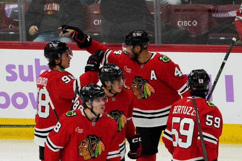 Jan 26, 2025; Chicago, Illinois, USA; Chicago Blackhawks defenseman Seth Jones (4) celebrates his goal against the Minnesota Wild with center Connor Bedard (98) during the third period at United Center. Mandatory Credit: David Banks-Imagn Images