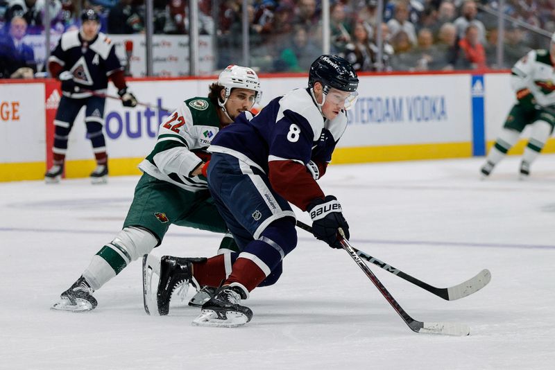 Apr 9, 2024; Denver, Colorado, USA; Colorado Avalanche defenseman Cale Makar (8) controls the puck under pressure from Minnesota Wild center Marat Khusnutdinov (22) in the first period at Ball Arena. Mandatory Credit: Isaiah J. Downing-USA TODAY Sports