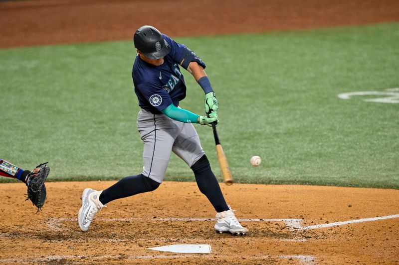 Sep 22, 2024; Arlington, Texas, USA; Seattle Mariners third baseman Dylan Moore (25) hits a double against the Texas Rangers during the sixth inning at Globe Life Field. Mandatory Credit: Jerome Miron-Imagn Images