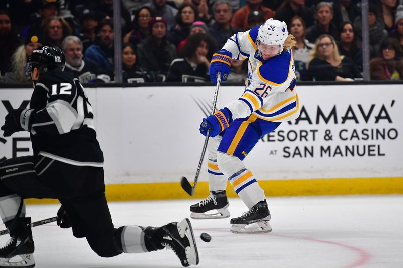 Feb 13, 2023; Los Angeles, California, USA; Buffalo Sabres defenseman Rasmus Dahlin (26) shoots against the defense of Los Angeles Kings left wing Trevor Moore (12) during the third period at Crypto.com Arena. Mandatory Credit: Gary A. Vasquez-USA TODAY Sports