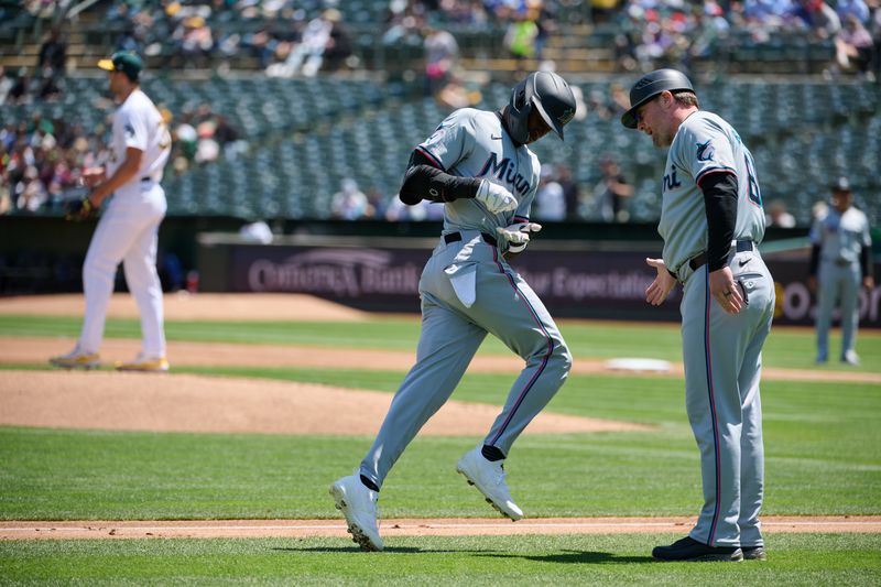 May 5, 2024; Oakland, California, USA; Miami Marlins outfielder Nick Gordon (1) celebrates with third base coach Griffin Benedict (81) after hitting a three run home run against the Oakland Athletics during the first inning at Oakland-Alameda County Coliseum. Mandatory Credit: Robert Edwards-USA TODAY Sports