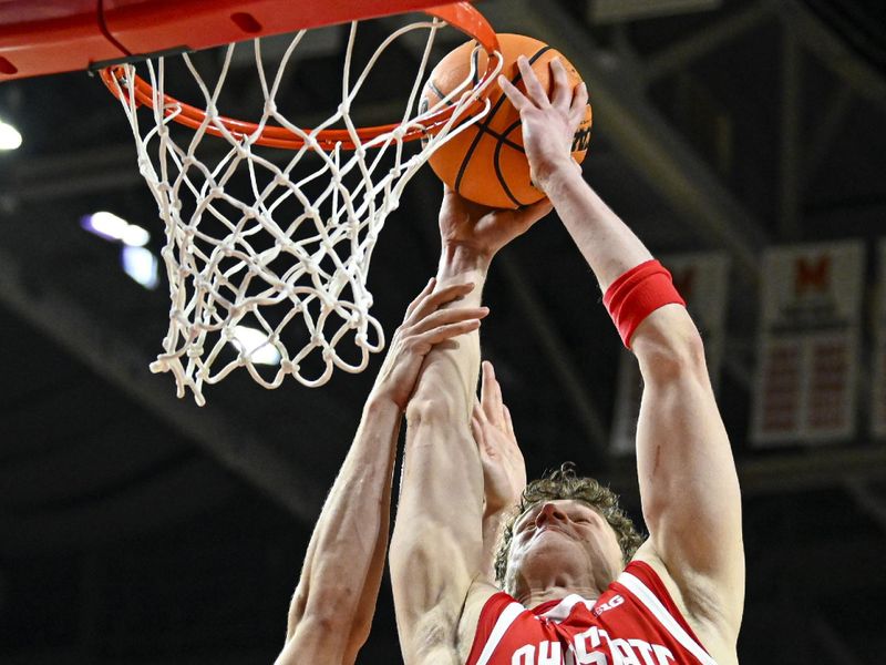 Feb 5, 2026; College Park, Maryland, USA;  Ohio State Buckeyes center Christoph Tilly (13) dunks over Maryland Terrapins forward Elijah Saunders (13) during the first half at Xfinity Center. Mandatory Credit: Tommy Gilligan-Imagn Images