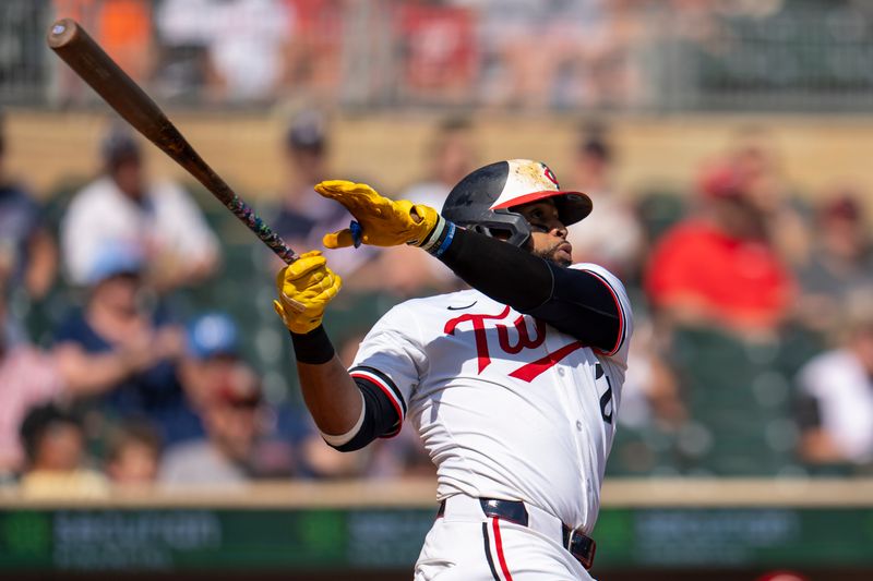 Sep 15, 2024; Minneapolis, Minnesota, USA; Minnesota Twins first baseman Carlos Santana (21) hits a single against the Cincinnati Reds in the fourth inning at Target Field. Mandatory Credit: Jesse Johnson-Imagn Images