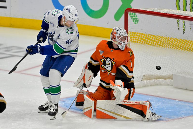 Nov 5, 2024; Anaheim, California, USA; The puck flies past Vancouver Canucks center Elias Pettersson (40) and Anaheim Ducks goaltender Lukas Dostal (1) for a score by Vancouver Canucks defenseman Quinn Hughes (43) in the second period shot by  at Honda Center. Mandatory Credit: Jayne Kamin-Oncea-Imagn Images