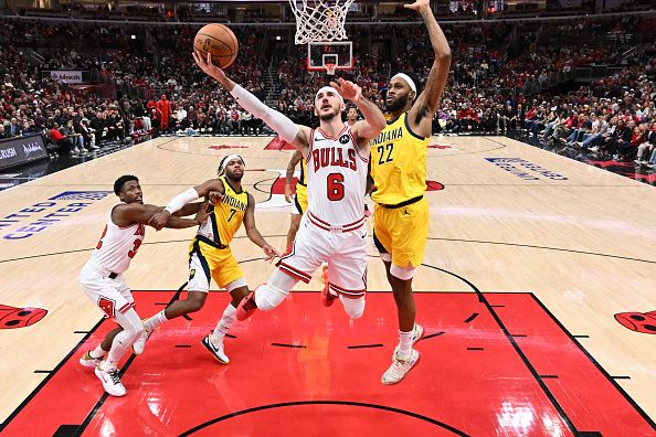 CHICAGO, ILLINOIS - DECEMBER 28:  Alex Caruso #6 of the Chicago Bulls attempts a lay up while being defended by Isaiah Jackson #22 of the Indiana Pacers in the second half on December 28, 2023 at the United Center in Chicago, Illinois. Indiana defeated Chicago 120-104.   NOTE TO USER: User expressly acknowledges and agrees that, by downloading and or using this photograph, User is consenting to the terms and conditions of the Getty Images License Agreement.  (Photo by Jamie Sabau/Getty Images)