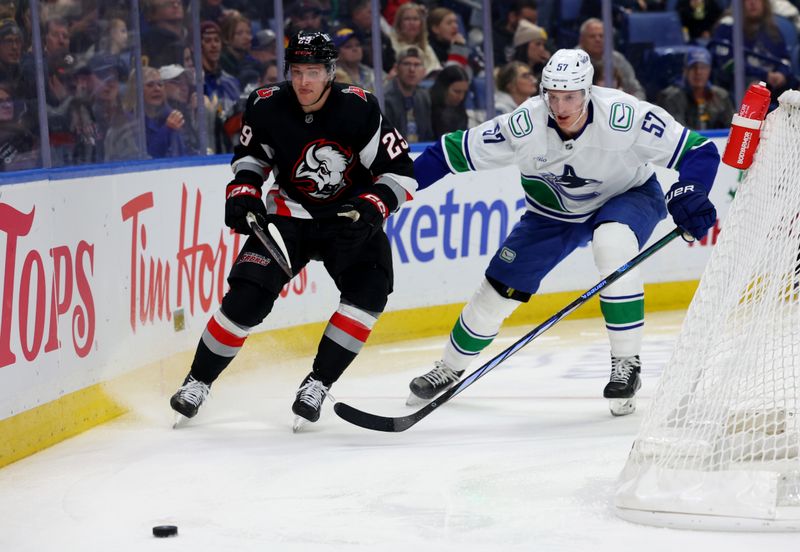 Nov 29, 2024; Buffalo, New York, USA;  Buffalo Sabres left wing Beck Malenstyn (29) and Vancouver Canucks defenseman Tyler Myers (57) go after a loose puck during the second period at KeyBank Center. Mandatory Credit: Timothy T. Ludwig-Imagn Images