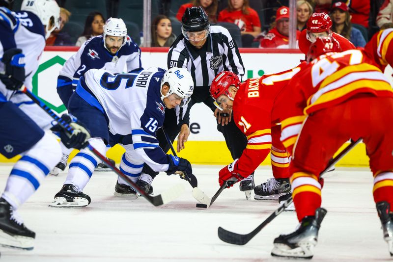 Oct 4, 2024; Calgary, Alberta, CAN; Winnipeg Jets center Rasmus Kupari (15) and Calgary Flames center Mikael Backlund (11) face off for the puck during the second period at Scotiabank Saddledome. Mandatory Credit: Sergei Belski-Imagn Images