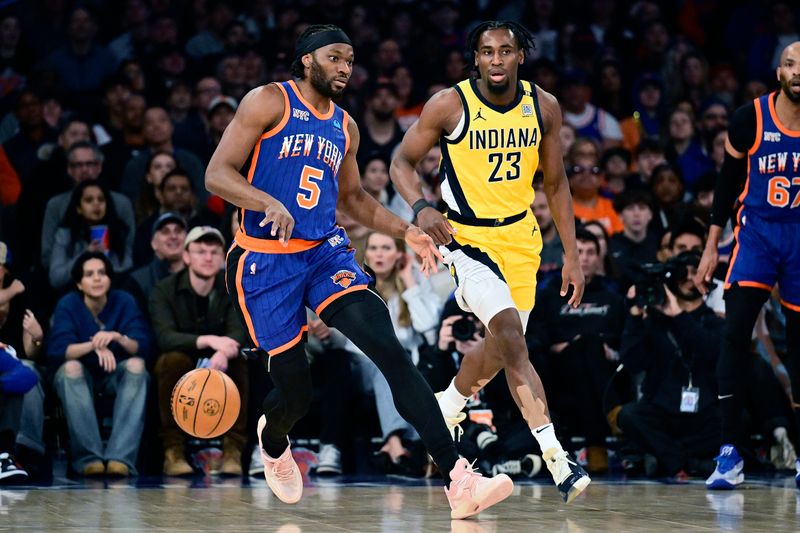 NEW YORK, NEW YORK - FEBRUARY 10:  Precious Achiuwa #5 of the New York Knicks is defended by Aaron Nesmith #23 of the Indiana Pacers during the first half at Madison Square Garden on February 10, 2024 in New York City. NOTE TO USER: User expressly acknowledges and agrees that, by downloading and or using this photograph, User is consenting to the terms and conditions of the Getty Images License Agreement. (Photo by Steven Ryan/Getty Images)