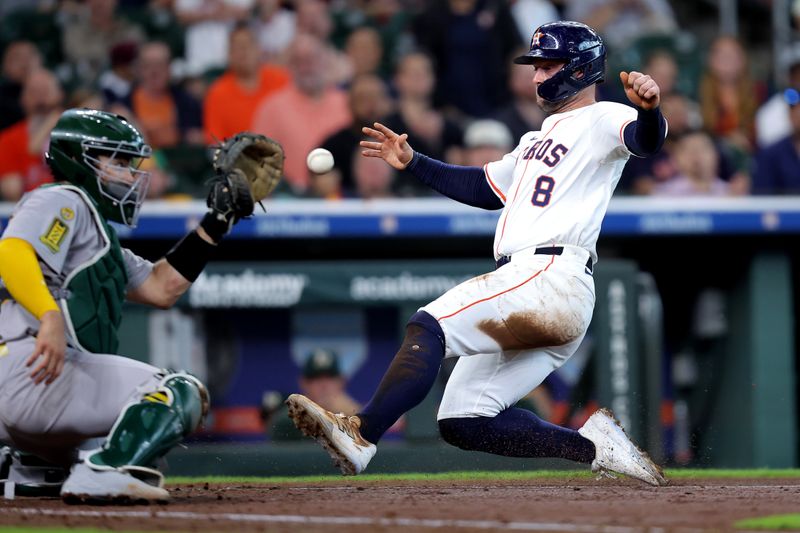 May 28, 2025; Houston, Texas, USA; Houston Astros first baseman Christian Walker (8) slides into home plate against the Athletics during the fourth inning at Daikin Park. Mandatory Credit: Erik Williams-Imagn Images