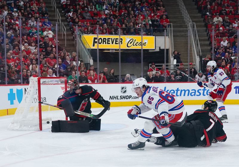 Nov 27, 2024; Raleigh, North Carolina, USA;  New York Rangers left wing Brett Berard (65) scares a goal past Carolina Hurricanes goaltender Spencer Martin (41) and defenseman Dmitry Orlov (7) during the second period at Lenovo Center. Mandatory Credit: James Guillory-Imagn Images