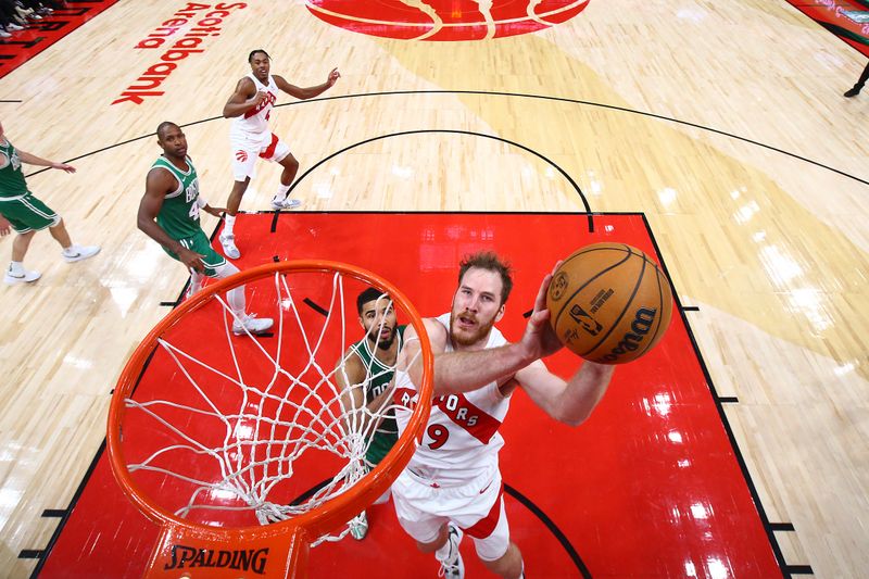 TORONTO, CANADA - OCTOBER 15:  Jakob Poeltl #19 of the Toronto Raptors drives to the basket during the game against the Boston Celtics on October 15, 2024 at the Scotiabank Arena in Toronto, Ontario, Canada.  NOTE TO USER: User expressly acknowledges and agrees that, by downloading and or using this Photograph, user is consenting to the terms and conditions of the Getty Images License Agreement.  Mandatory Copyright Notice: Copyright 2024 NBAE (Photo by Vaughn Ridley/NBAE via Getty Images)